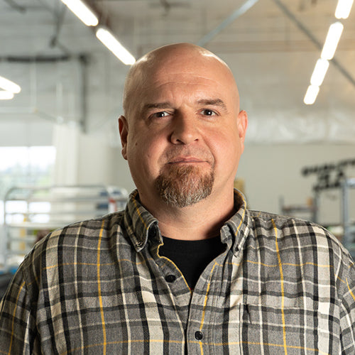 Man wearing a plaid shirt in an indoor setting