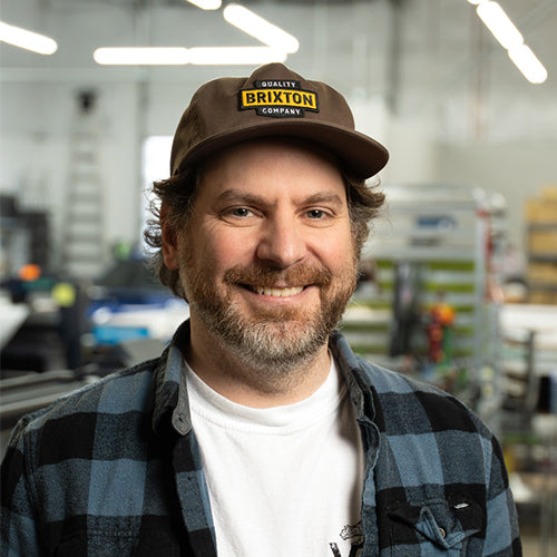 Man wearing a Brixton cap in an indoor setting