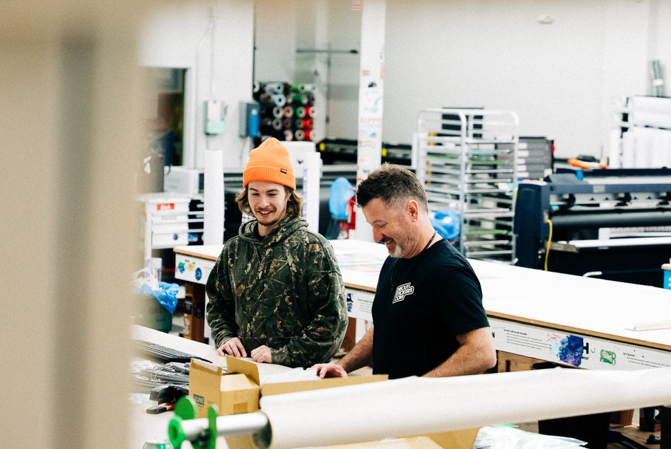 Two men working together in a warehouse or industrial setting.