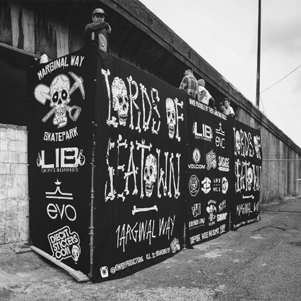 Black and white mural with various logos and text on a wall.